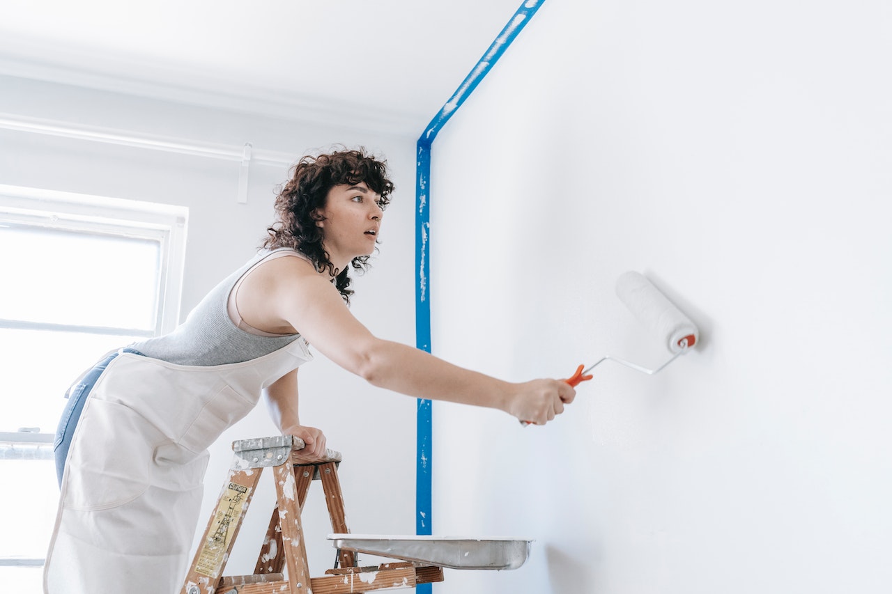 A woman painting a wall during home renovation.