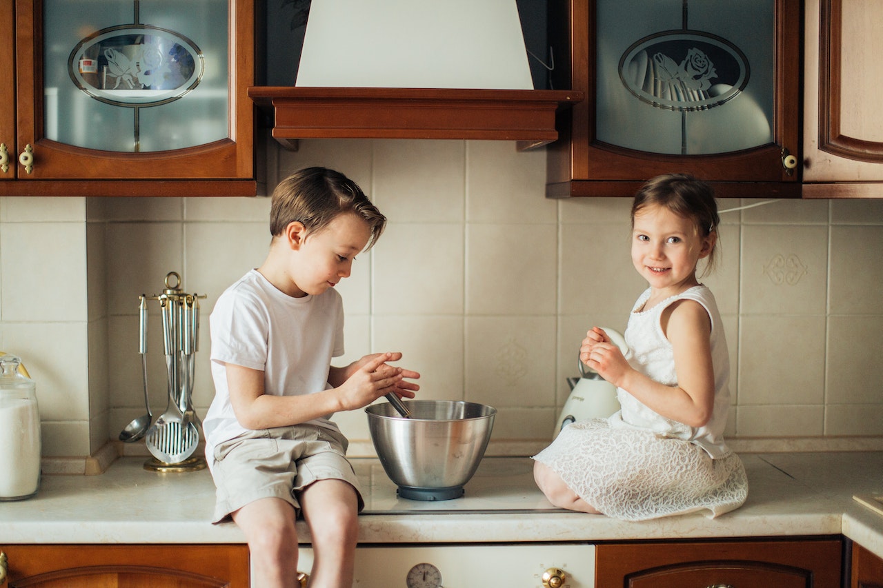 Kitchen with home appliances and kids posing.